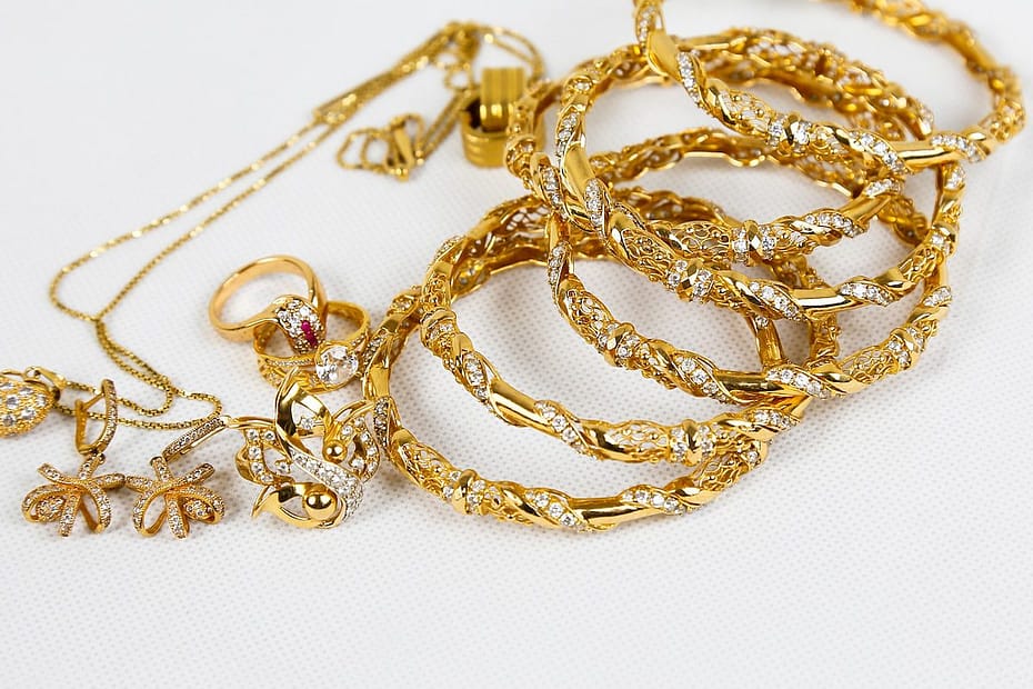 gold chain necklace on white surface