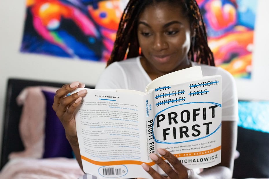 woman reading book on personal finance called profit first